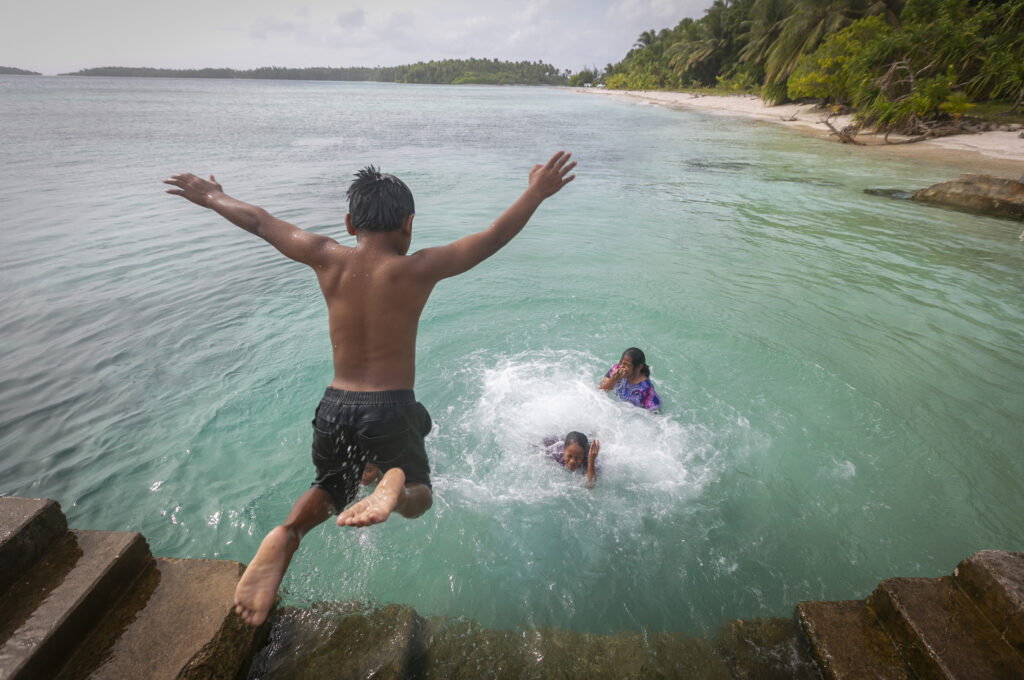 Boy jumping in ocean
